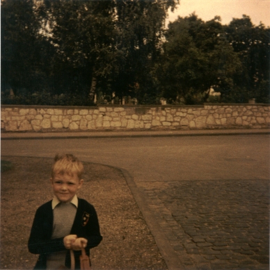 Farbphoto von der Sprengerstraße Ecke Struckmannstraße im Jahre 1967 in Hildesheim: Ein Junge an seinem ersten Schultag. Er hält seinen Leder-Ranzen mit den Händen.