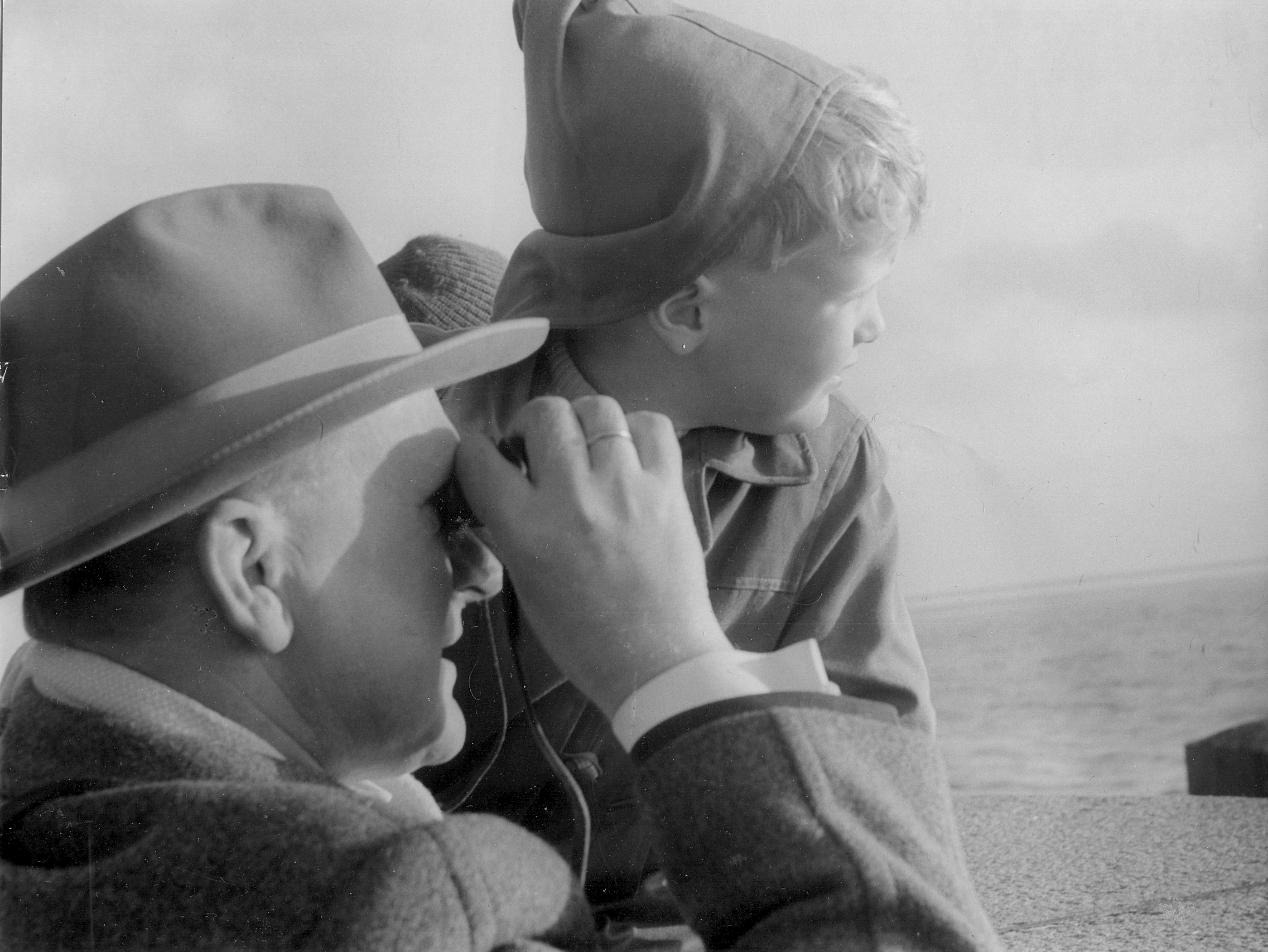 Schwarz-Weiß-Foto: Ein Emder mit seinem Sohn auf der Mole in Emden im Jahre 1960. Fotografin: I.O.